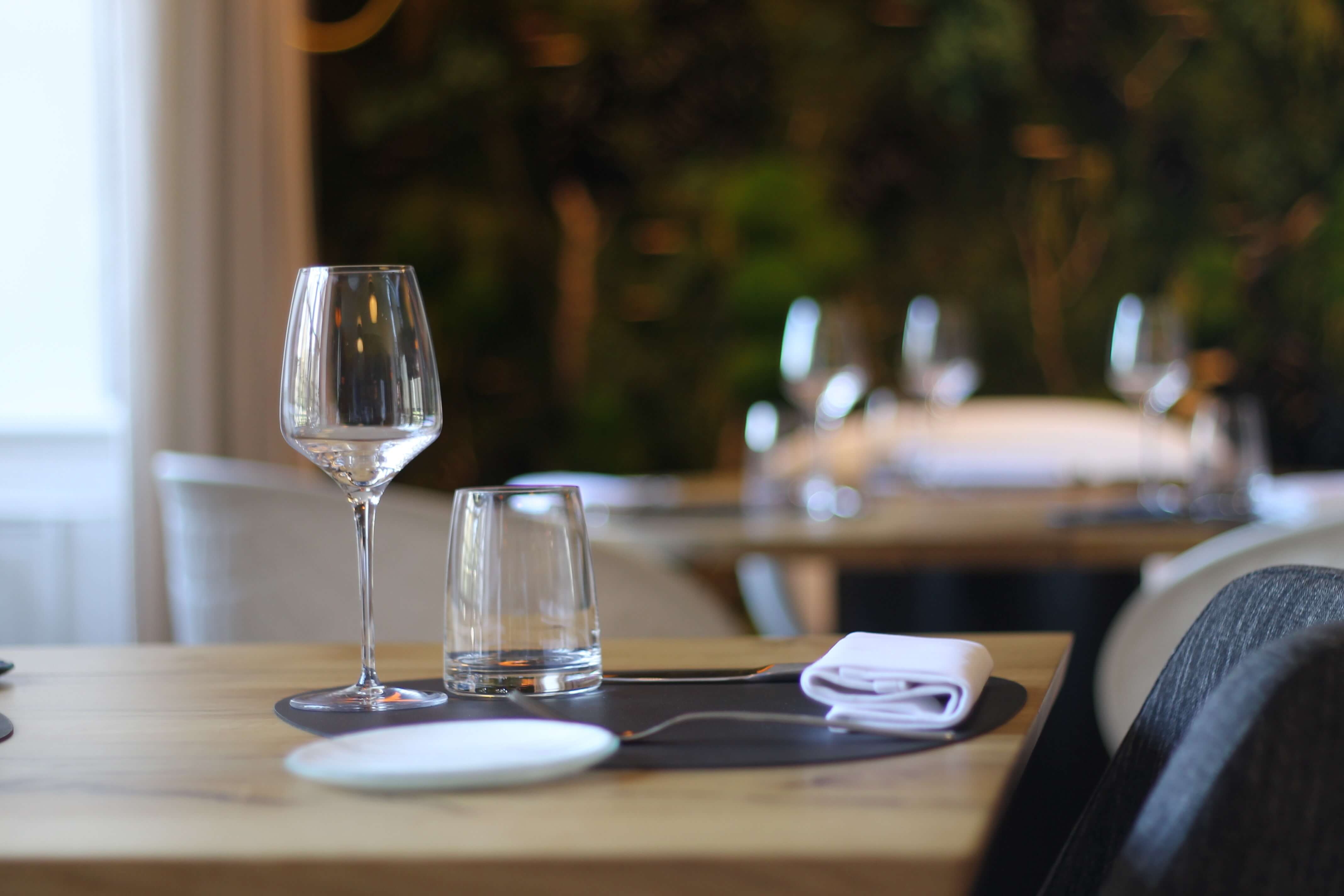 Placemat with glass, silverwear and napkin in an empty restaurant