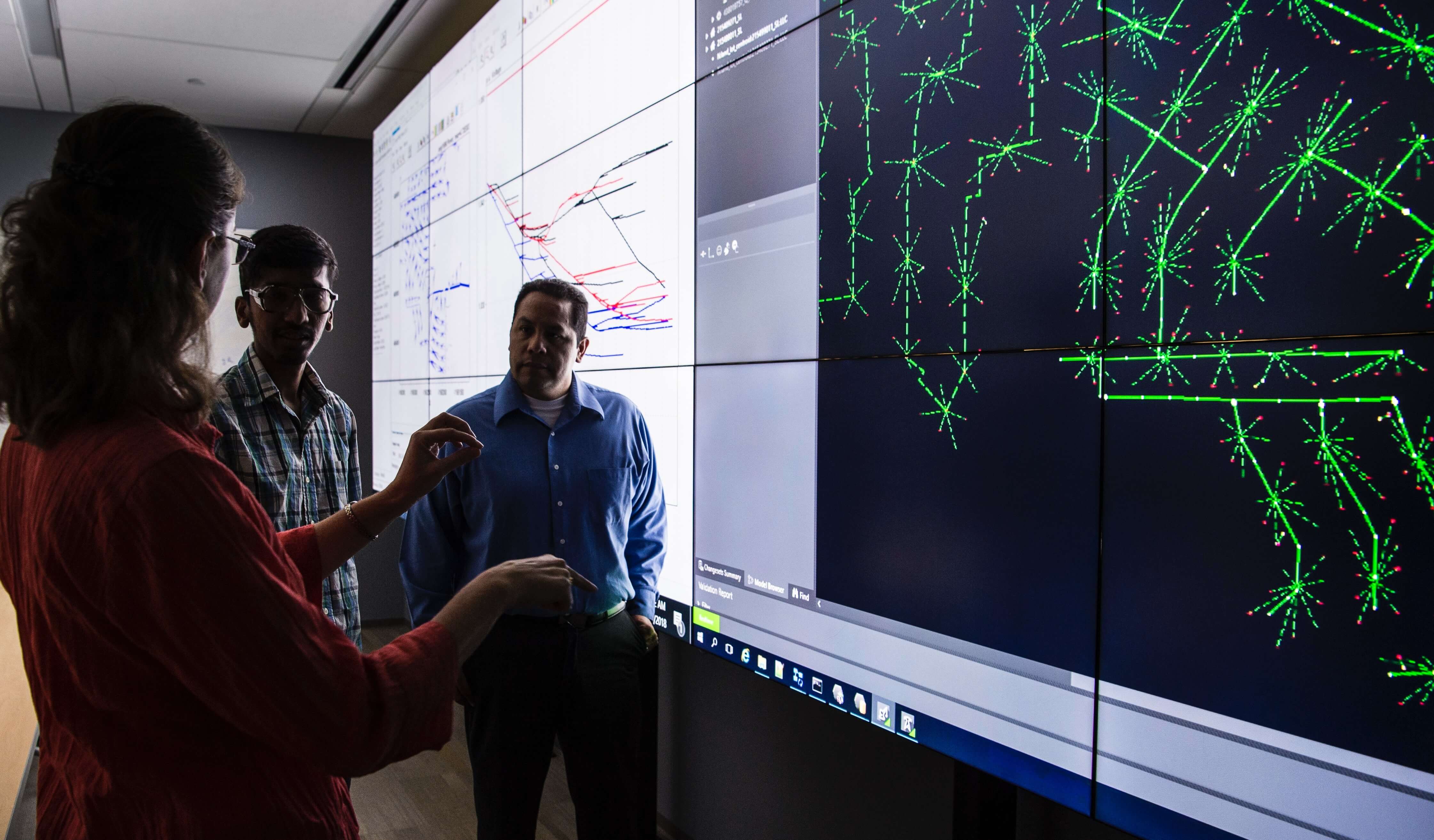 small group examining large screen showing a simulation